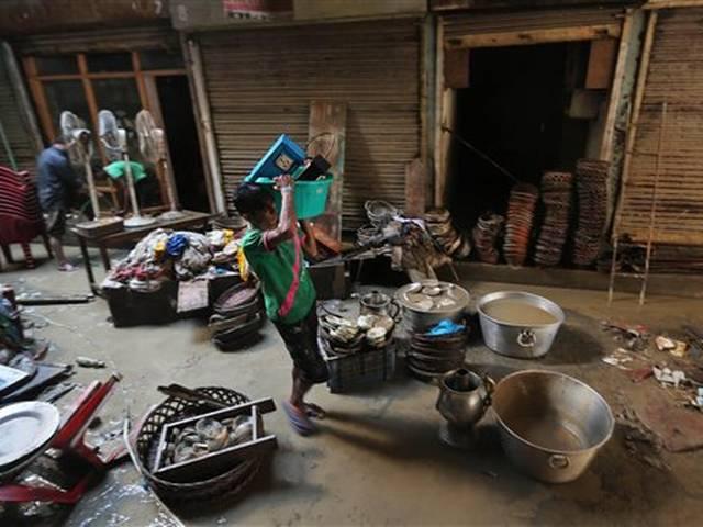 बाढ़ का पानी घटने के बीच लोग अपना बचा खुचा सामान एकत्र करने में जुटे As flood water recedes, people scramble to salvage whatever is